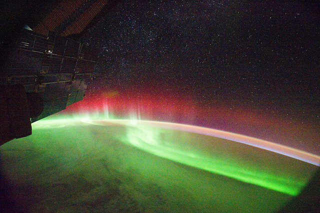 (Kuva NASA/Flickr, kuvateksti mukana) NASA image captured September 26, 2011 Many aurora appear green, but sometimes — as in this image from the International Space Station — other colors such as red can appear. The colors depend on which atoms are causing the splash of light seen in the aurora. In most cases, the light comes when a charged particle sweeps in from the solar wind and collides with an oxygen atom in Earth’s atmosphere. This produces a green photon, so most aurora appear green. However, lower-energy oxygen collisions as well as collisions with nitrogen atoms can produce red photons -- so sometimes aurora also show a red band as seen here. Karen Fox NASA's Goddard Space Flight Center Credit: NASA